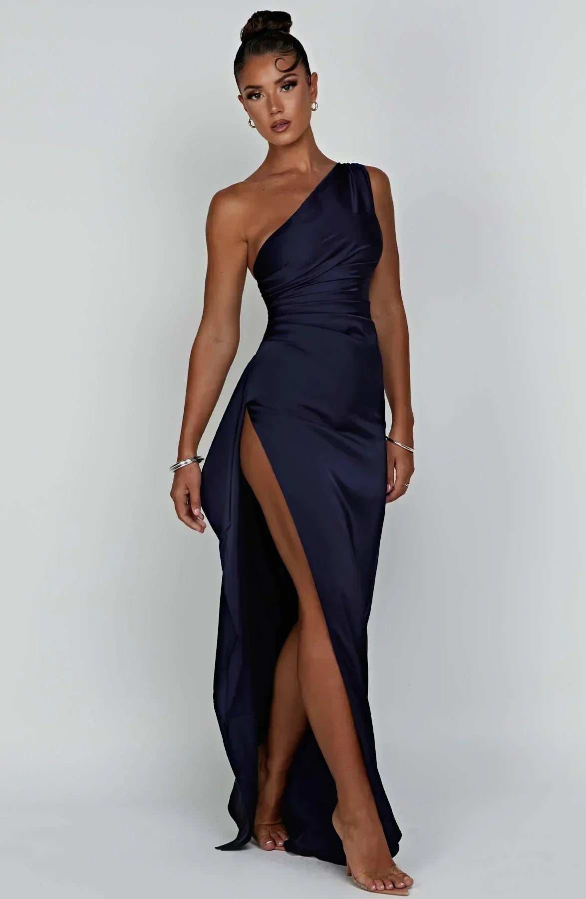 Frau in dunkelblauem, schulterfreiem Abendkleid mit hohem Schlitz, elegantes Design.