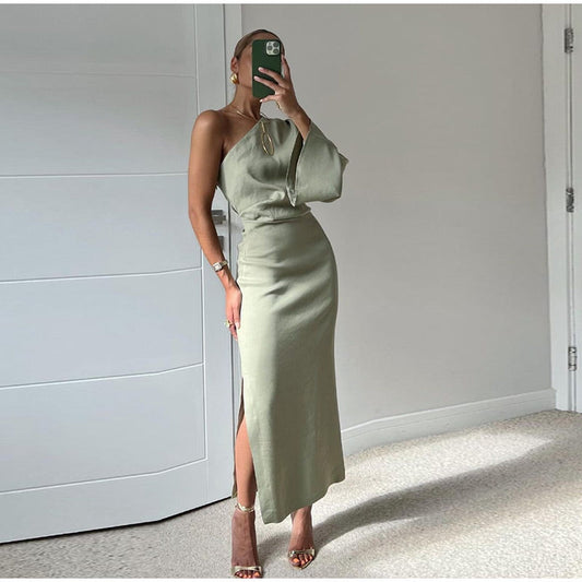 Frau in grünem, schulterfreiem Kleid mit Schlitz, elegantes Abendoutfit, modisch, modern.