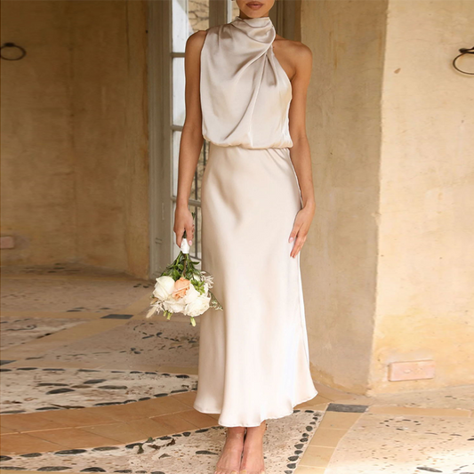 Frau in cremefarbenem Satinkleid mit Blumenstrauß, elegantes Abendkleid, Hochzeitsmode.