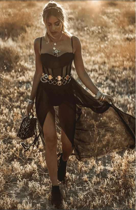 Frau im schwarzen Retro-Kleid mit Schmuck, Sommerwiese, Modefotografie, Boho-Stil.