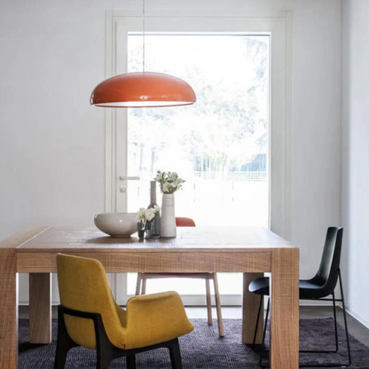 Moderner Essbereich mit Holztisch, gelbem Stuhl, roter Hängelampe und Blumenvasen.