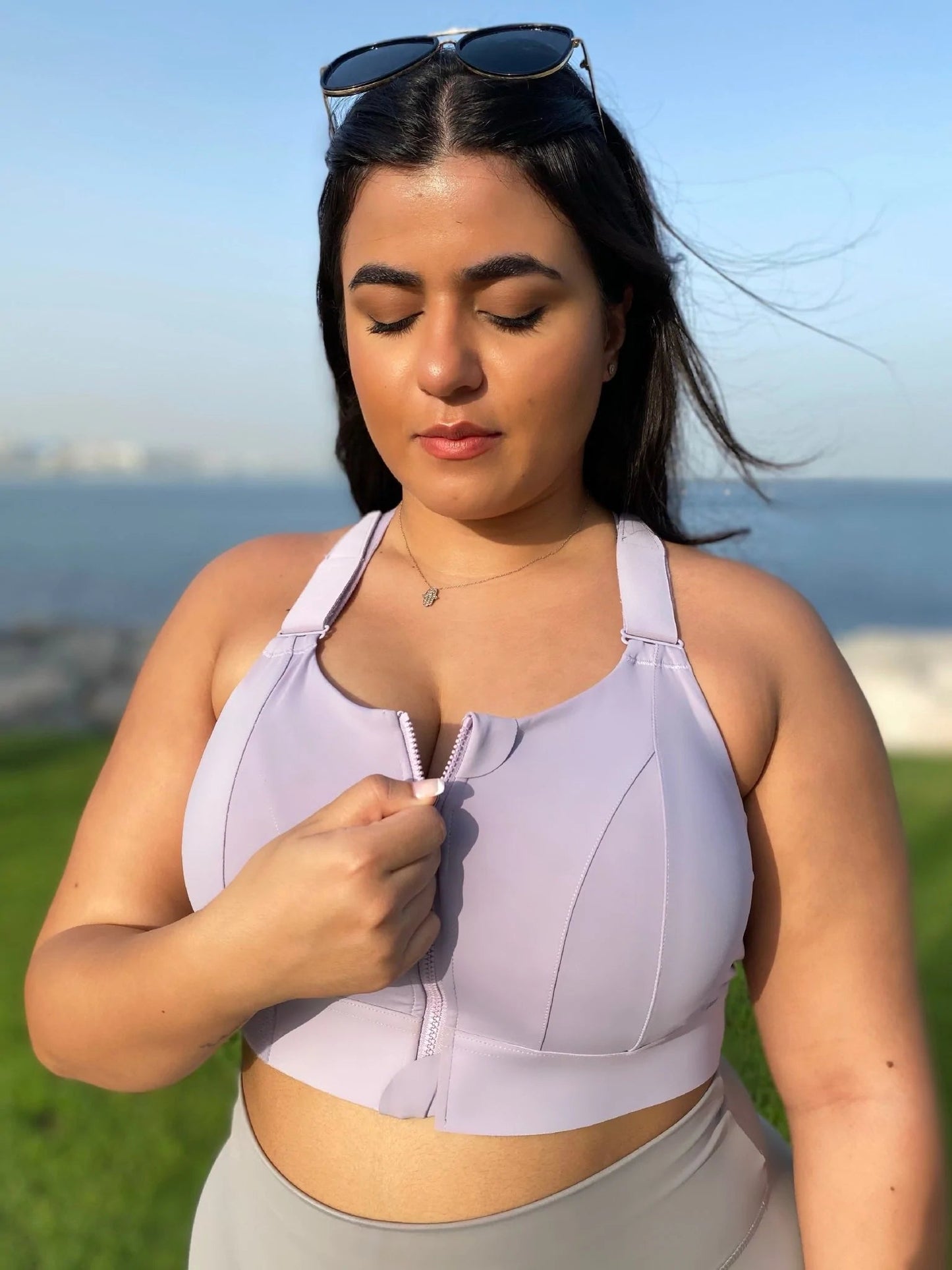 Frau in lila Sport-BH mit Reißverschluss, hoher Halt, Outdoor, Fitness, Sommermode.