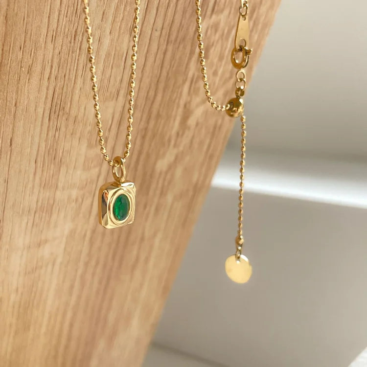 Goldene Halskette mit grünem Edelstein-Anhänger, elegantes Schmuckdesign, Damenaccessoire.