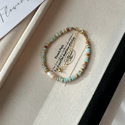 Armband mit blauen und goldenen Perlen, handgefertigt, in Schmuckschatulle, elegantes Design.