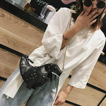 Frau mit schwarzer Dinosaurier-Handtasche aus Leder, goldene Kette, modisches Accessoire.