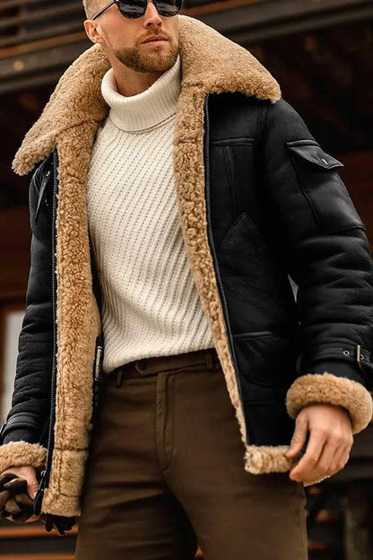 Mann in schwarzer Lederjacke mit beigem Lammfell, weißem Rollkragenpullover, brauner Hose.