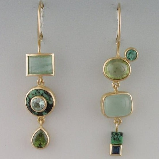 Goldene Ohrringe mit grünen Edelsteinen, geometrisches Design, eleganter Schmuck für Damen.