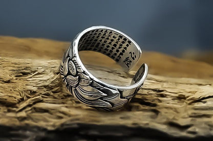 Silberner verstellbarer Ring mit Blumenmuster, handgefertigt, auf Holzuntergrund.