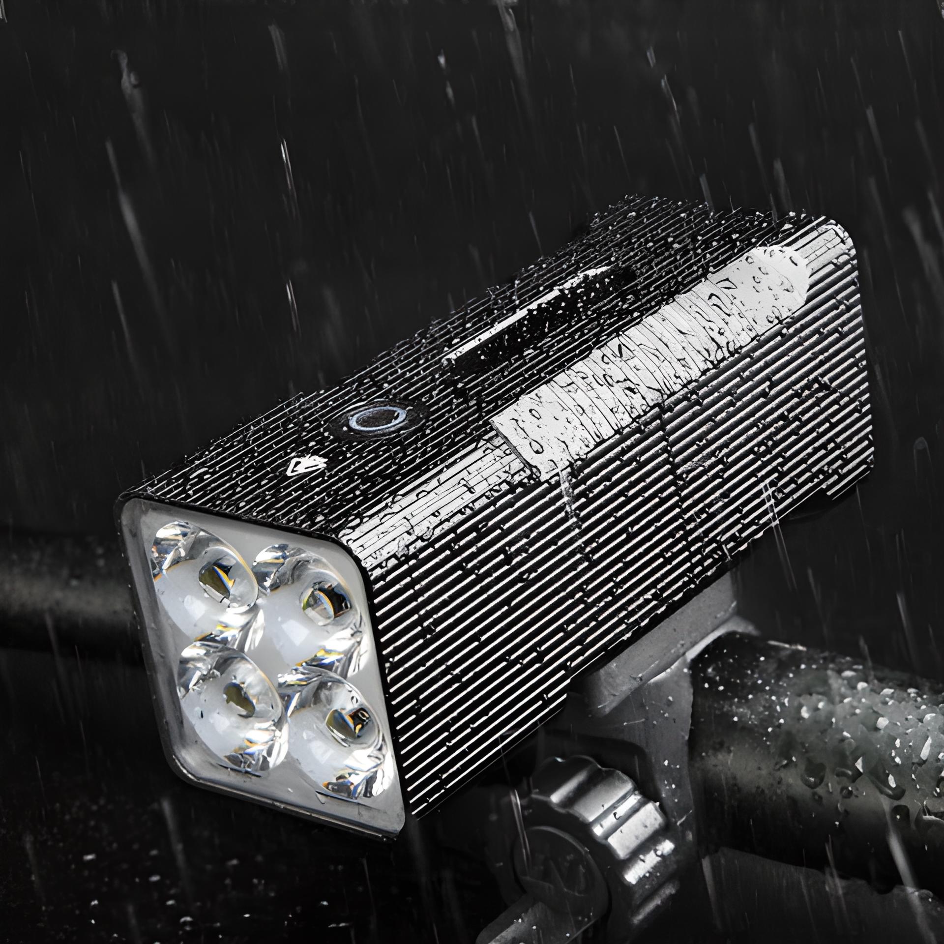 Wasserdichte LED-Fahrradleuchte, schwarz, mit vier Linsen, montiert auf Lenker, bei Regen.