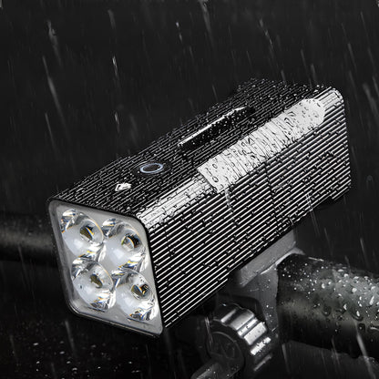 Wasserdichte LED-Fahrradleuchte, schwarz, mit vier Linsen, montiert auf Lenker, bei Regen.