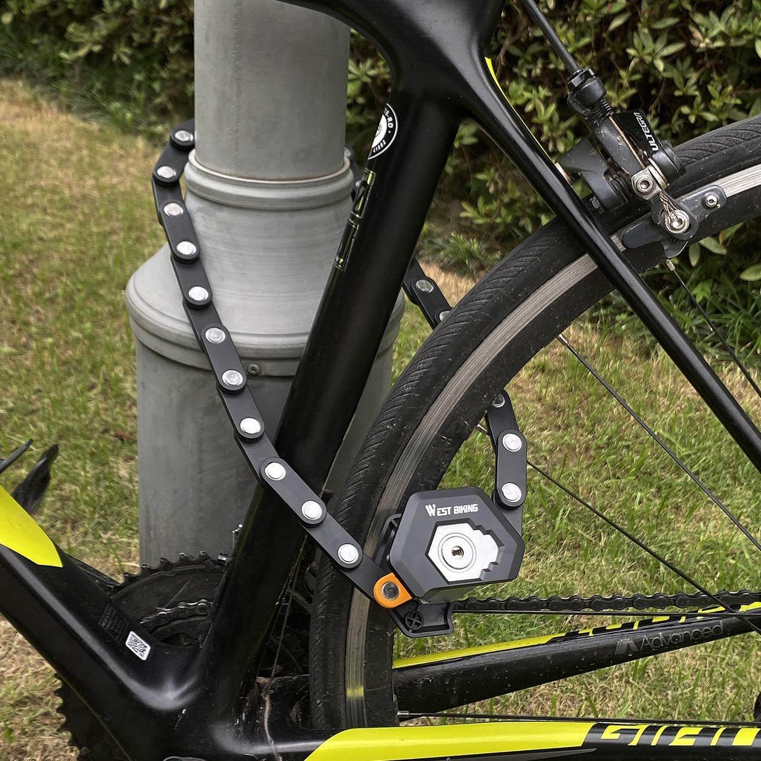Schwarzes Faltschloss sichert Fahrrad an Laternenpfahl, robustes Diebstahlschutz-Zubehör.