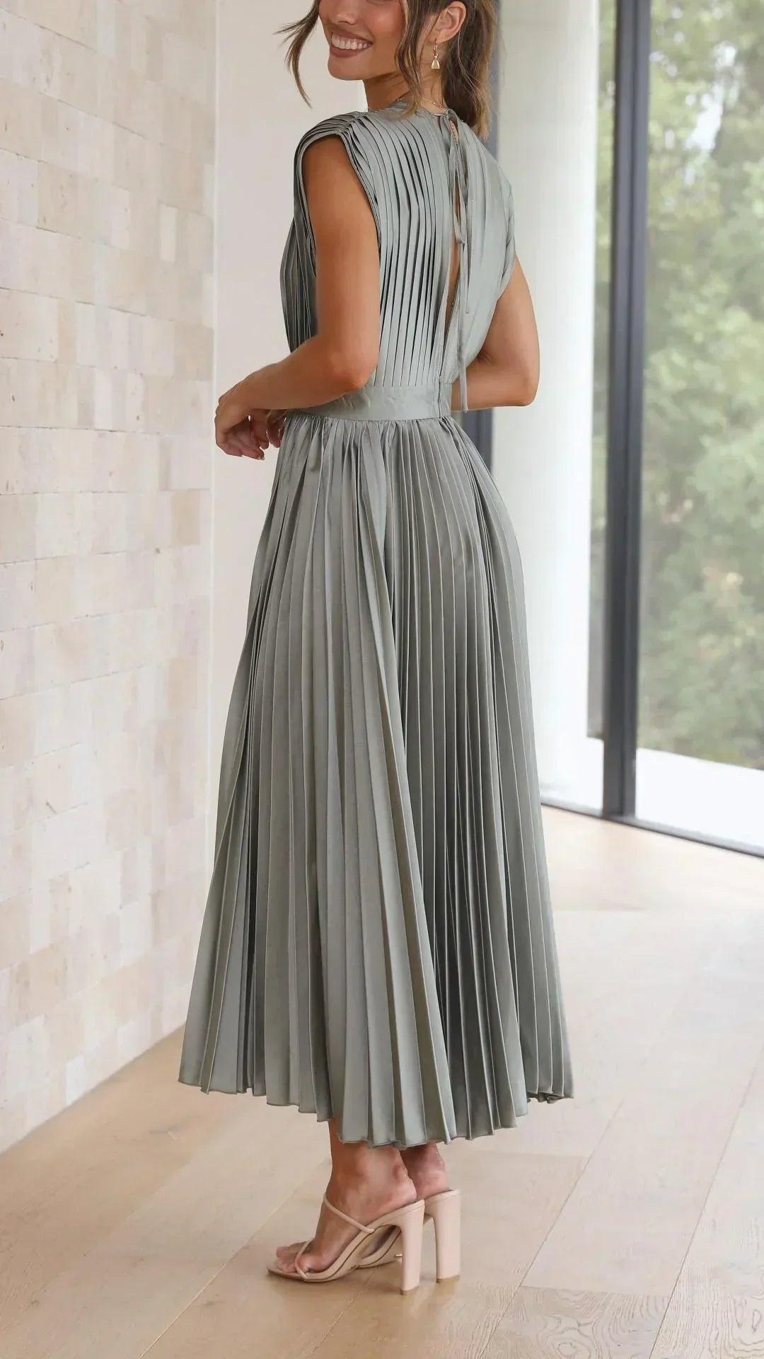 Frau in olivgrünem, plissiertem Maxikleid aus Chiffon, elegant, modern, Sommermode.