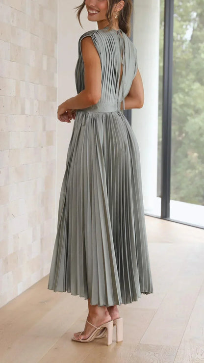 Frau in olivgrünem, plissiertem Maxikleid aus Chiffon, elegant, modern, Sommermode.