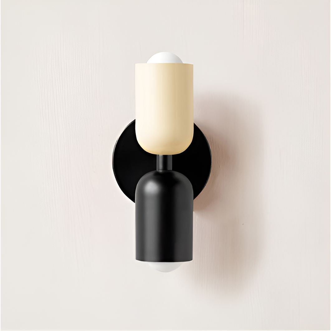 Vägglampa med gräddvit övre skärm, svart nedre skärm och svart rund väggplatta, sedd framifrån. 31