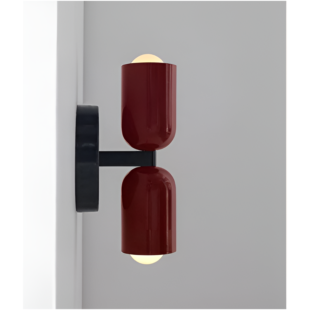 Sidovy av vägglampa med två rödbruna lampskärmar och svart arm som visar hur lampan sticker ut från väggen, med tända glödlampor. 17