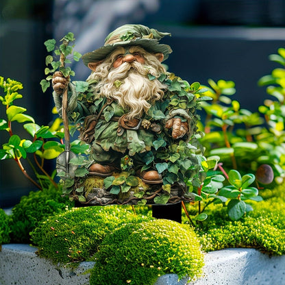 Skäggig tomte med bladklädsel och spade, stående på en mosstuva bland gröna växter. 13