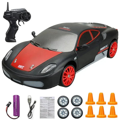 Ferngesteuertes Auto Set, schwarz-rot, mit Fernbedienung, Ersatzrädern, Ladegerät und Pylonen.