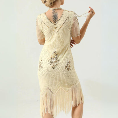 Frau in cremefarbenem, besticktem Fransen-Kleid mit Tattoo am Rücken, Vintage-Stil.