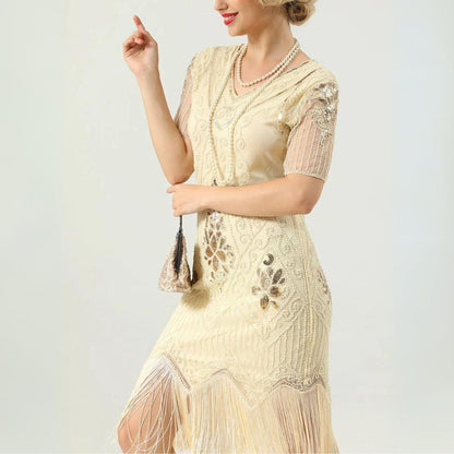 Frau in cremefarbenem, besticktem Fransen-Kleid im Vintage-Stil mit Perlenkette.