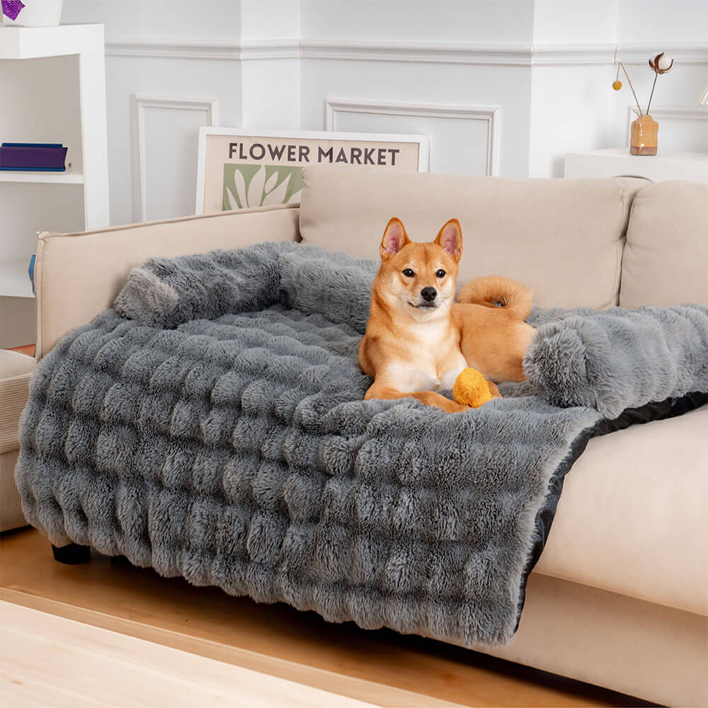 Hund auf grauem, flauschigem Sofaüberwurf, beruhigendes Haustierbett, Wohnzimmer.