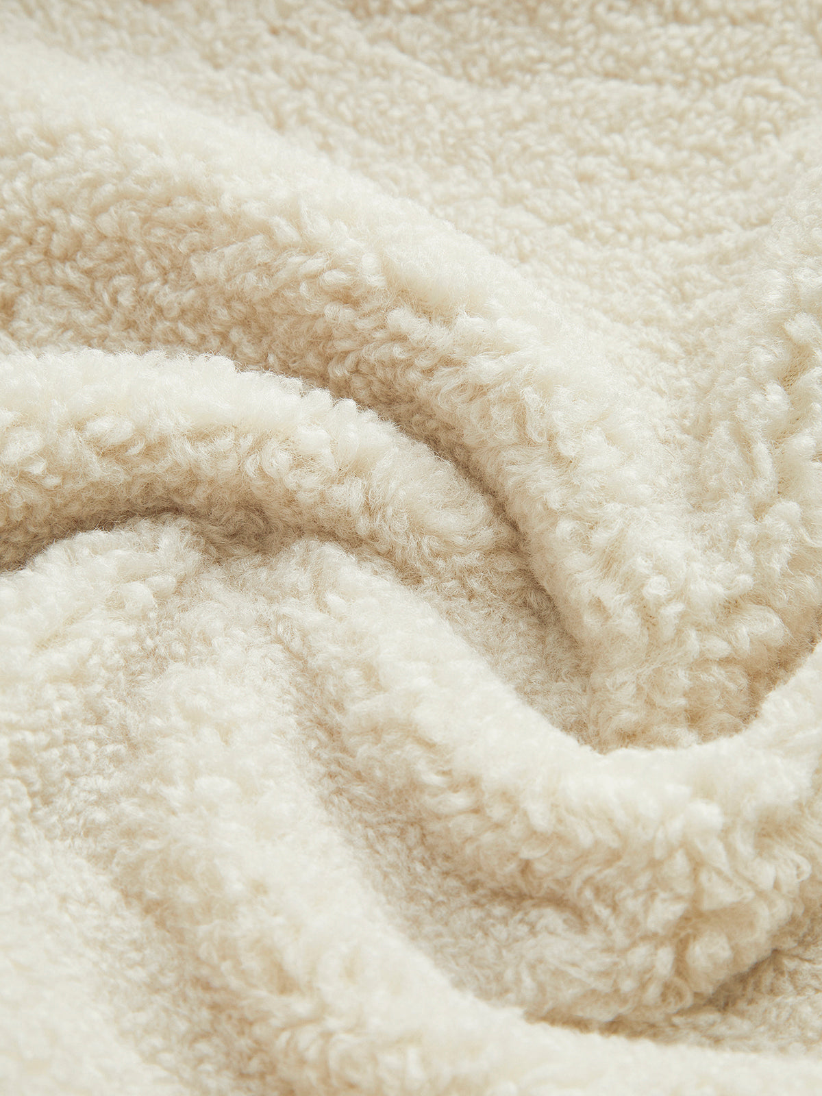 Weiche cremefarbene Fleece-Decke, kuscheliges Material, ideal für gemütliche Abende.