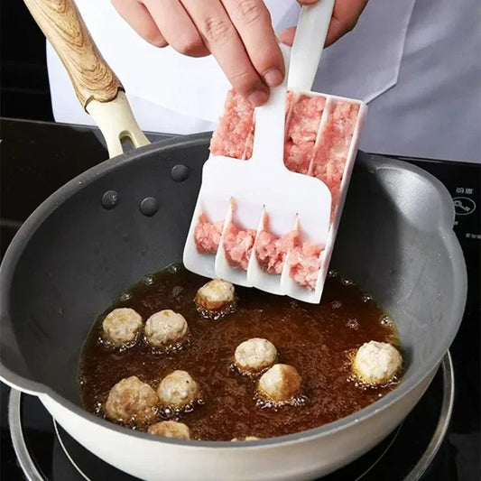 Person formt Fleischbällchen mit weißem Fleischformer in grauer Pfanne auf Herd.
