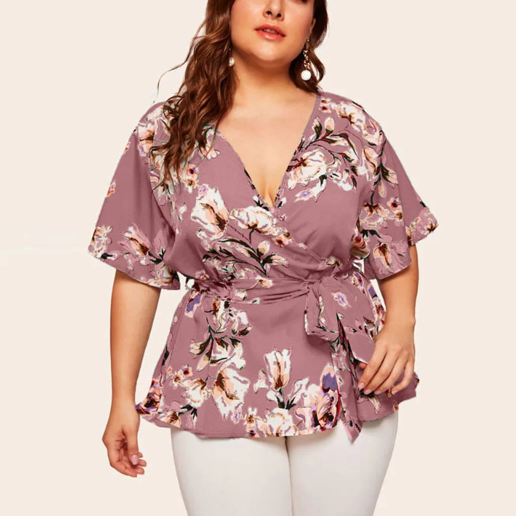 Frau in lila Blumenbluse mit V-Ausschnitt und Gürtel, Plus-Size-Mode, Sommerkleidung.