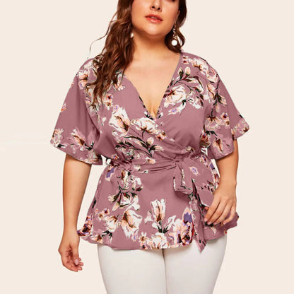Frau in lila Blumenbluse mit V-Ausschnitt und Gürtel, Plus-Size-Mode, Sommerkleidung.