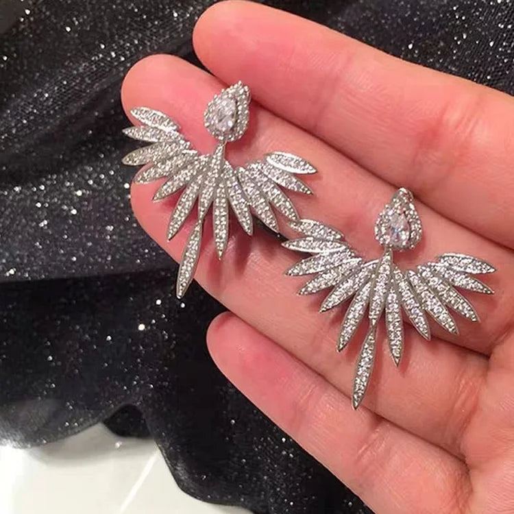 Silberne Ohrringe mit Flügel-Design, funkelnde Strasssteine, eleganter Schmuck für Damen.