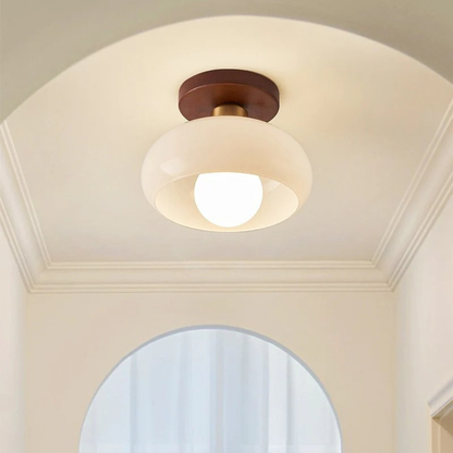Tänd plafond med mässingsdetalj i ett välvt tak ovanför en rundbågig öppning 3
