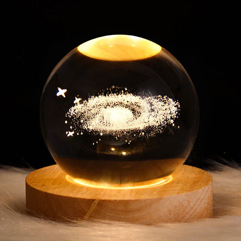 Leuchtende Kristallkugel mit Galaxie-Design auf Holzsockel, dekorative LED-Lampe.