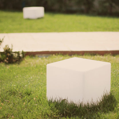 Weiße LED-Gartenleuchte in Würfelform auf Rasen, moderne Außenbeleuchtung.