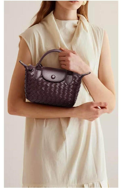 Frau mit brauner geflochtener Handtasche aus Leder, elegantes Design, modisches Accessoire.