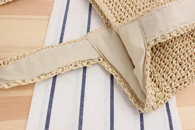 Geflochtene Strohtasche auf gestreiftem Stoff, beige, umweltfreundlich, modisch, Sommeraccessoire.