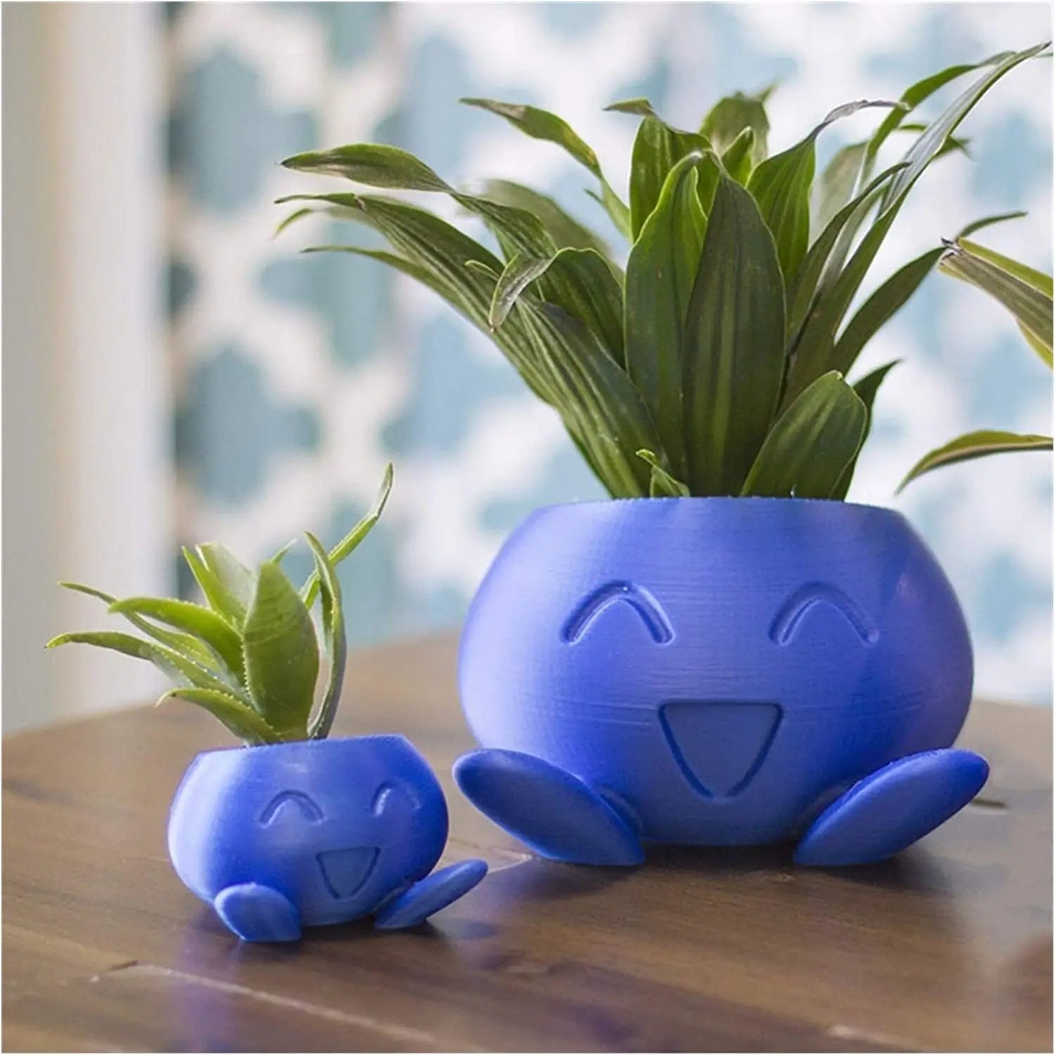 Blaue, lächelnde Pflanzentöpfe aus Kunststoff mit Pflanzen, dekorativ, modern, für Innenräume.