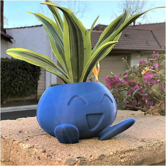 Blaue, lächelnde Pflanzentopf-Figur mit grüner Pflanze, dekorativer Blumentopf, Gartenaccessoire.