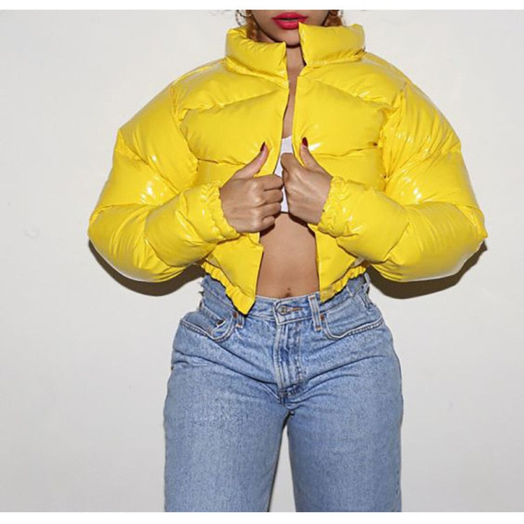 Frau in gelber Daunenjacke, blaue Jeans, modische Winterkleidung, leuchtende Farben.