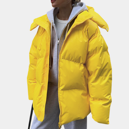Frau in gelber Daunenjacke, Kapuze, Wintermode, lässiger Stil, Outdoor-Bekleidung.