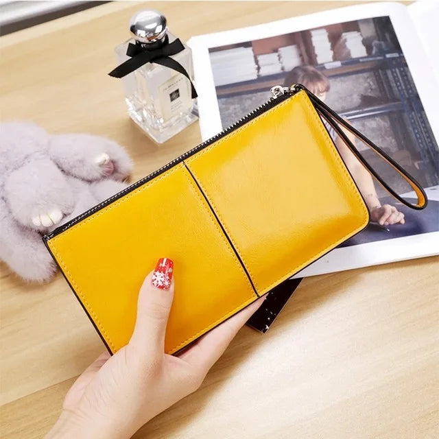 Gelbe Lederhandtasche mit Reißverschluss, Damenmode, elegantes Design, auf Holztisch.
