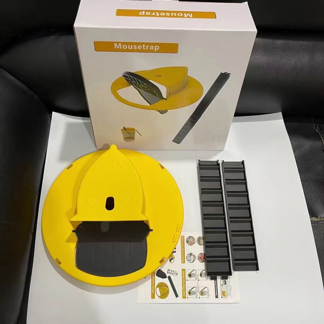 Gelbe Mausefalle aus Kunststoff, runde Form, mit Verpackung und Zubehör auf schwarzem Hintergrund.
