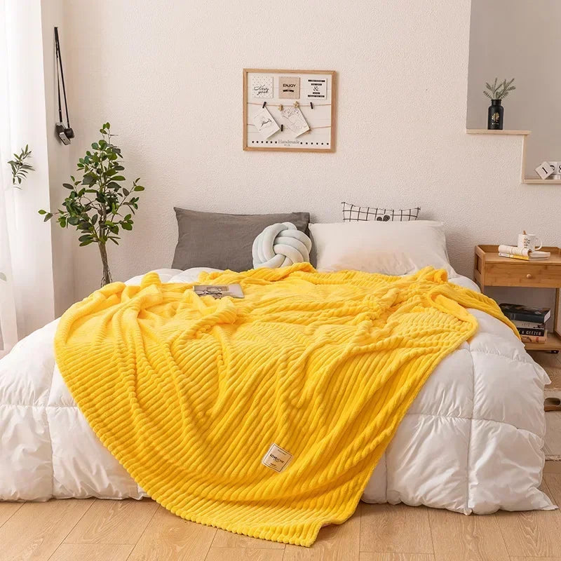 Gelbe Strickdecke auf weißem Bett, gemütliches Schlafzimmer, moderne Inneneinrichtung.