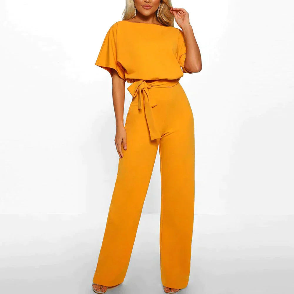 Frau in gelbem Jumpsuit mit Gürtel, Kurzarm, elegantes Design, modische Damenbekleidung.