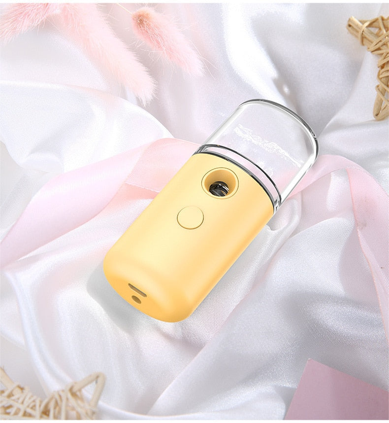 Gelber tragbarer Gesichtsdampfer auf weißem Satin, Hautpflegegerät, USB-aufladbar.