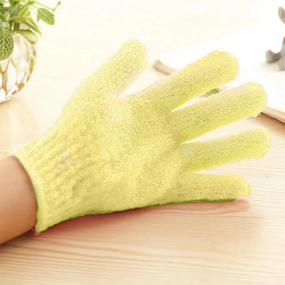 Gelber Peeling-Handschuh aus Baumwolle auf Holztisch, ideal für sanfte Hautpflege.