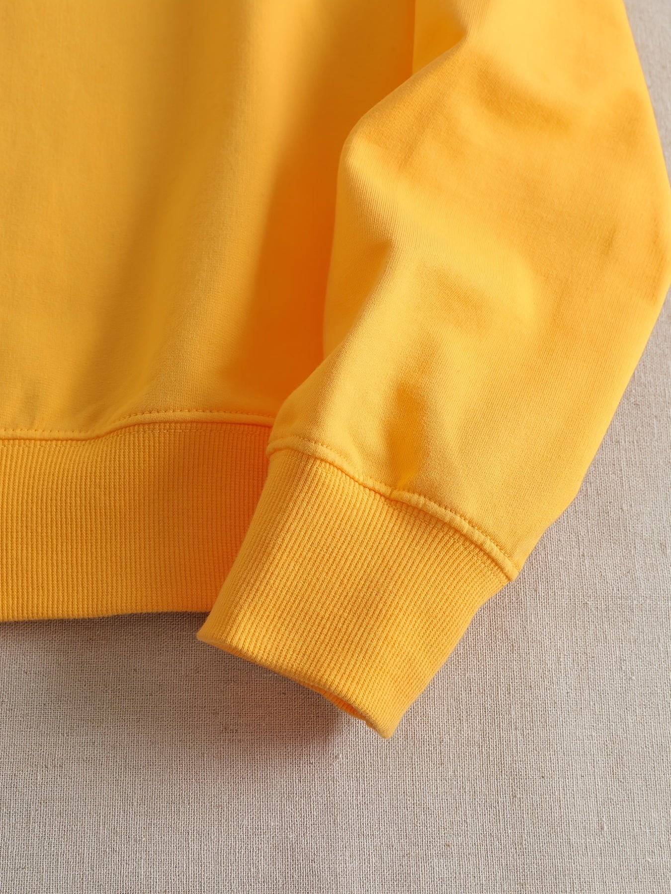 Gelber Baumwollpullover Ärmel Detailansicht, modisch, bequem, hochwertig, Freizeitkleidung.