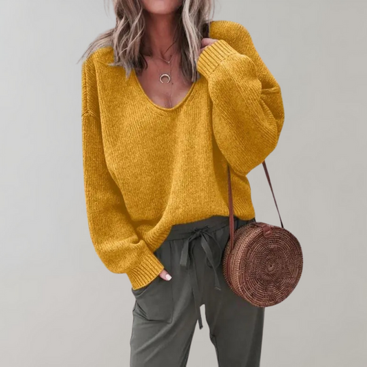 Frau in gelbem Strickpullover, olivgrüner Hose, runder Strohtasche, modisch, lässig.
