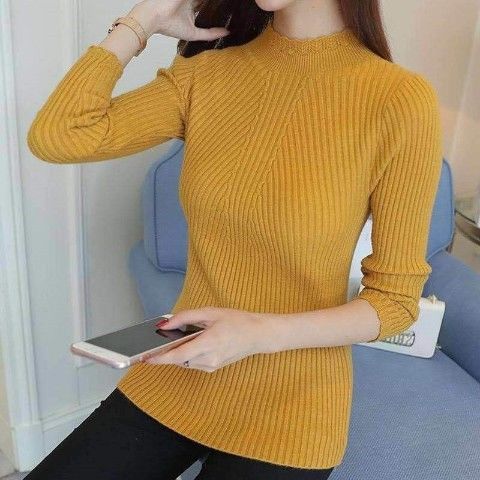 Frau in senfgelbem Strickpullover mit Smartphone, modisch, Herbstmode, Damenbekleidung.