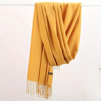 Gelber Kaschmirschal mit Fransen, weiches Material, modisches Accessoire für Herbst und Winter.
