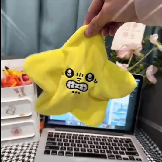 Gelber Stern-Stressball mit Gesicht, ideal für Stressabbau, auf Schreibtisch vor Laptop.