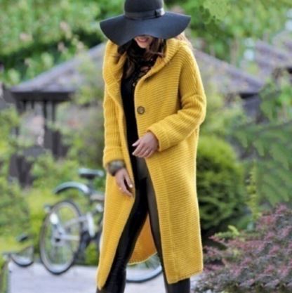 Frau in gelbem Strickmantel und schwarzem Hut im Freien, modisch, Herbstmode.